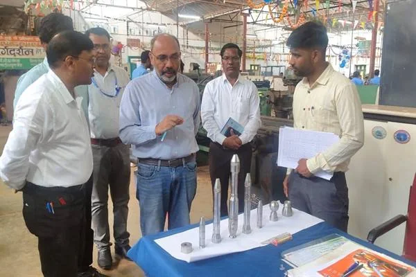 आईटीआई की कार्यशाला में मेज पर रखे धातु के नमूनों को देखते और चर्चा करते अधिकारी