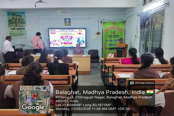 महाविद्यालय के कक्ष में बैठी छात्राओं के सामने मंच से संबोधित करती महिला और स्क्रीन पर प्रदर्शित कार्यक्रम का पोस्टर